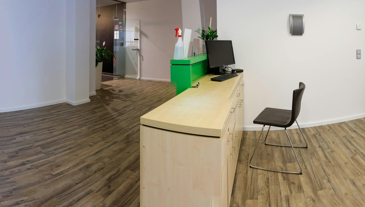 Moderne Bürorezeption mit Computer und Schutzwänden.